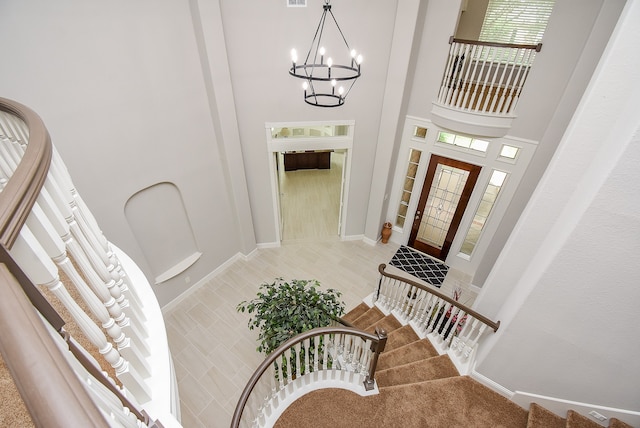 tiled foyer featuring a towering ceiling and a notable chandelier