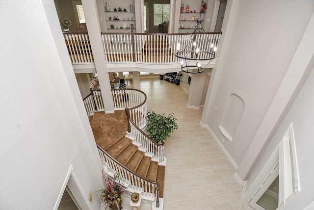 tiled entryway featuring an inviting chandelier and a towering ceiling