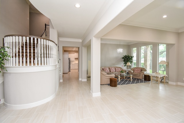 foyer entrance with ornamental molding and a notable chandelier