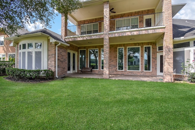 rear view of house featuring a balcony, a yard, and a patio area