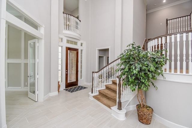 entrance foyer with a high ceiling and ornamental molding