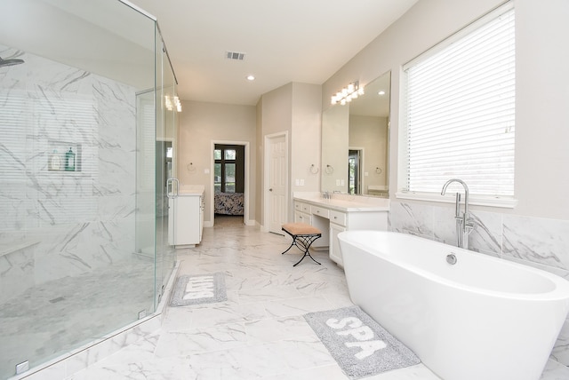 bathroom featuring vanity and independent shower and bath