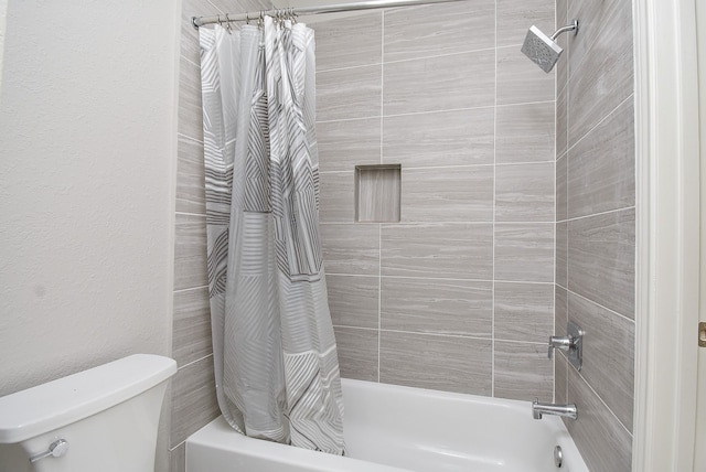 bathroom featuring toilet and shower / bath combination with curtain