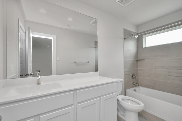 full bathroom with vanity, tiled shower / bath combo, and toilet