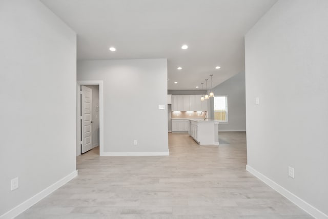 unfurnished living room featuring light hardwood / wood-style floors and an inviting chandelier
