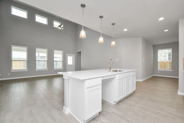 kitchen with plenty of natural light, an island with sink, and sink
