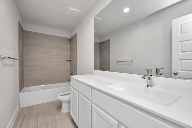 full bathroom featuring tiled shower / bath combo, toilet, and vanity