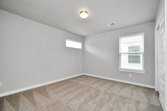 carpeted spare room featuring plenty of natural light