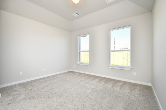 carpeted empty room with lofted ceiling