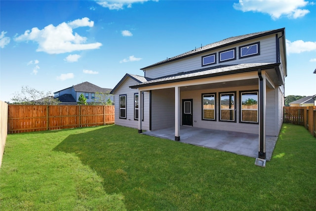 rear view of house featuring a yard and a patio