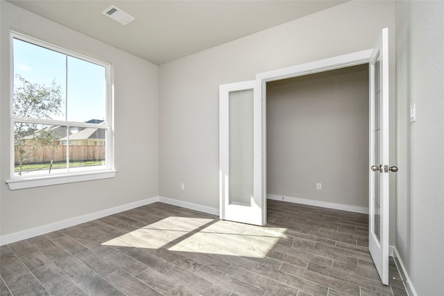 unfurnished bedroom with french doors and dark wood-type flooring