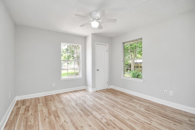 empty room with light wood-style floors, baseboards, and a ceiling fan