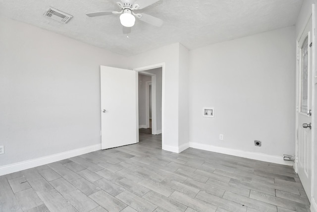 interior space featuring baseboards, visible vents, ceiling fan, and wood finished floors