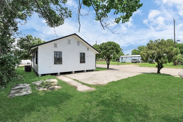 view of side of home with a yard and cooling unit