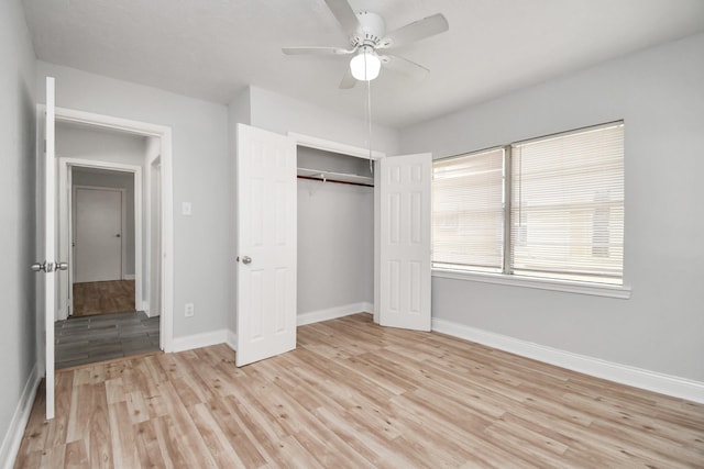 unfurnished bedroom with light wood-type flooring, a closet, ceiling fan, and baseboards