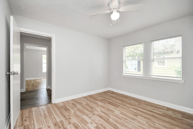 spare room with light wood-style flooring, baseboards, and ceiling fan