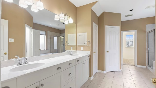 bathroom with a healthy amount of sunlight, a shower with shower door, tile patterned floors, and vanity