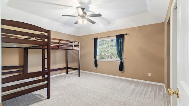 unfurnished bedroom with a tray ceiling, light colored carpet, and ceiling fan