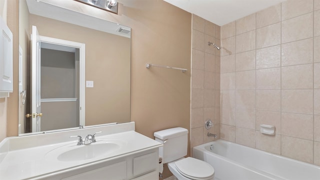 full bathroom featuring tiled shower / bath, toilet, and vanity