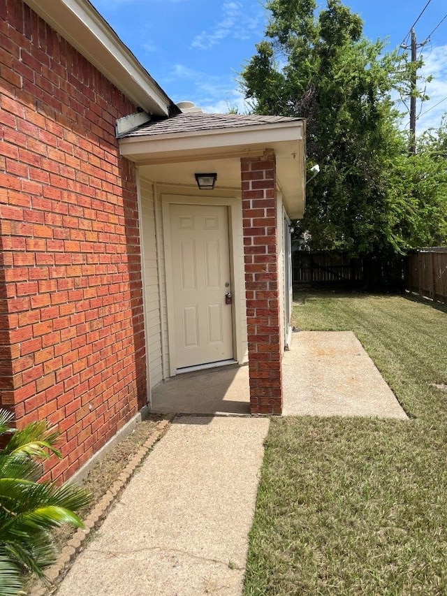 view of exterior entry with a lawn