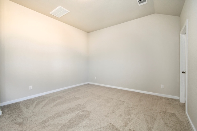 carpeted empty room with vaulted ceiling