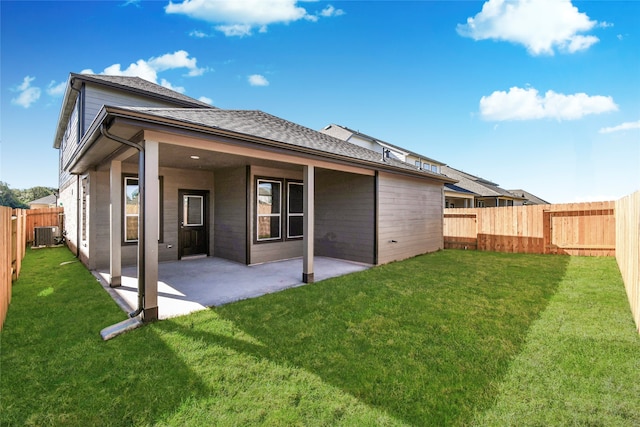 rear view of property featuring a yard, cooling unit, and a patio