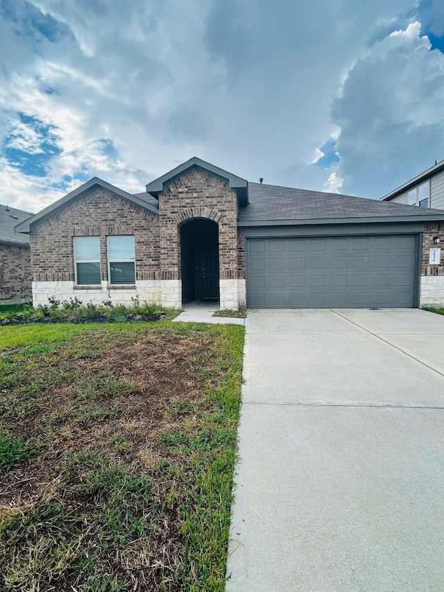 view of front of property featuring concrete driveway, an attached garage, brick siding, and roof with shingles