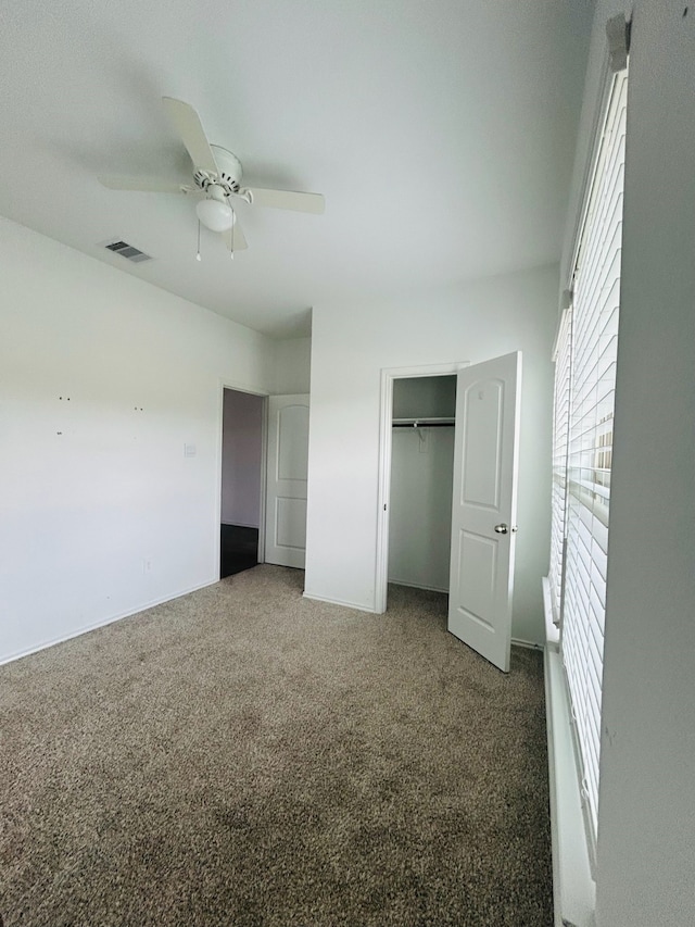 unfurnished bedroom with carpet flooring, a closet, and ceiling fan