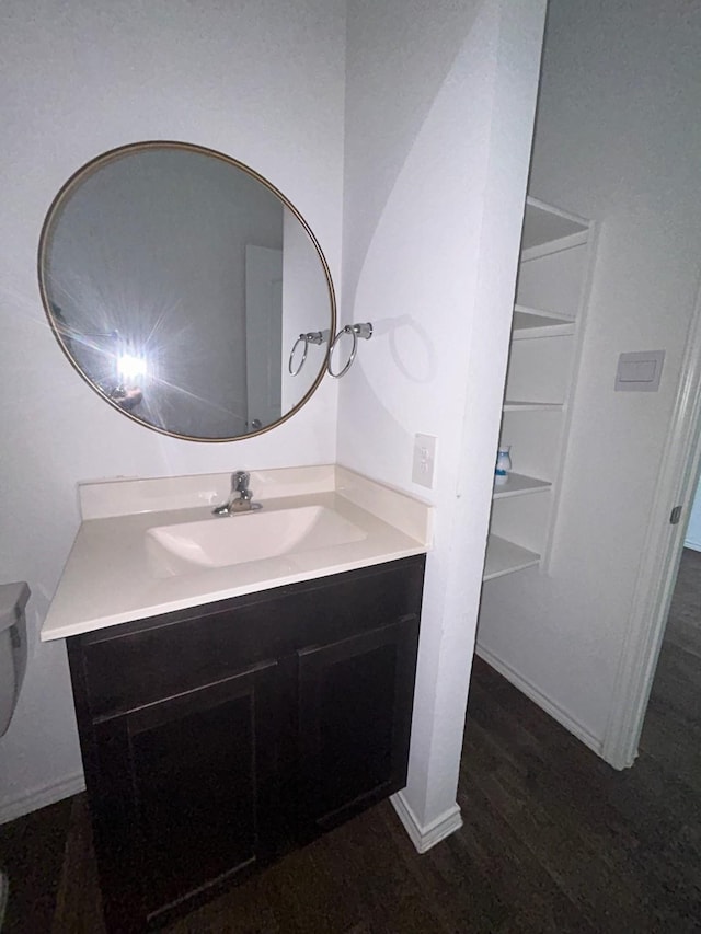 bathroom with vanity, wood finished floors, and baseboards