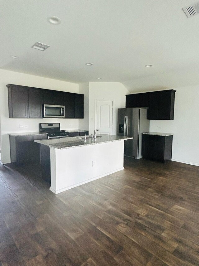 kitchen with a center island with sink, stainless steel appliances, sink, and dark hardwood / wood-style flooring