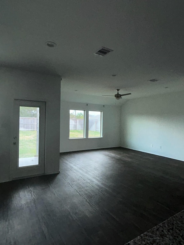 unfurnished room with dark wood-type flooring, visible vents, and ceiling fan