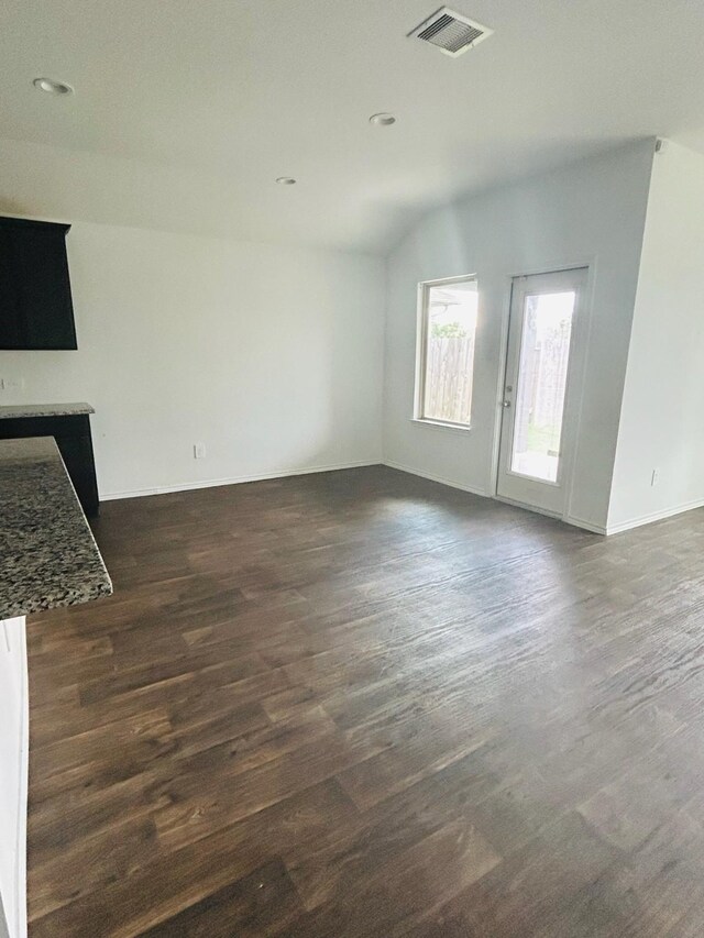 unfurnished living room featuring lofted ceiling and dark hardwood / wood-style floors