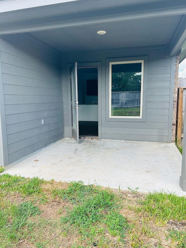 view of exterior entry with a patio area