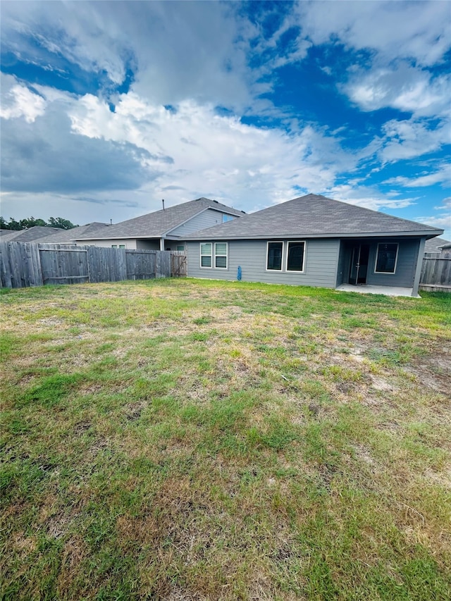 rear view of house featuring a yard