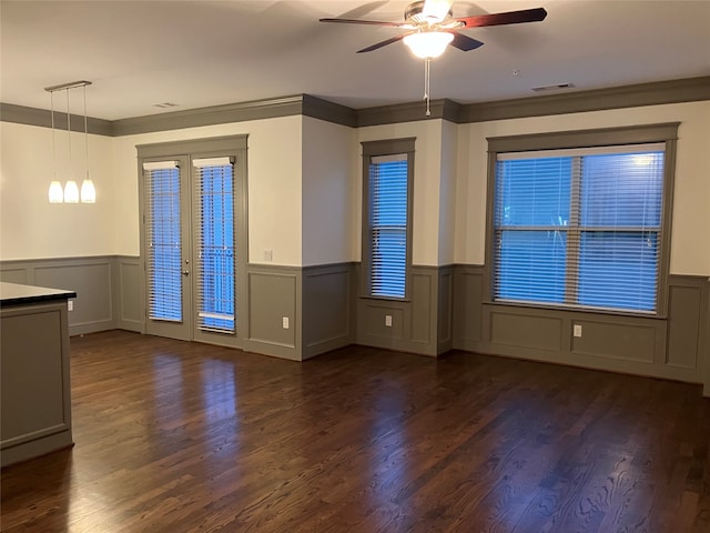 unfurnished living room featuring dark wood-type flooring, ceiling fan, ornamental molding, and french doors