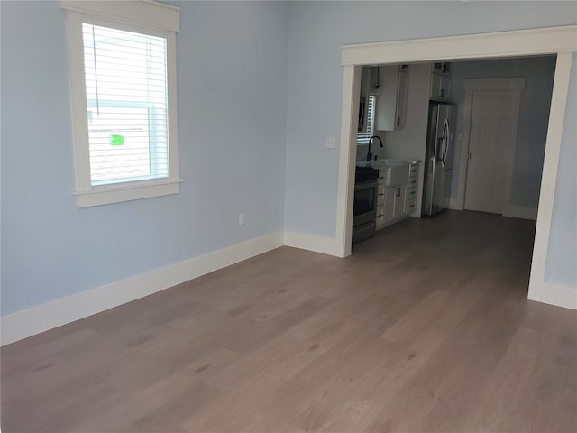 spare room with hardwood / wood-style floors and sink