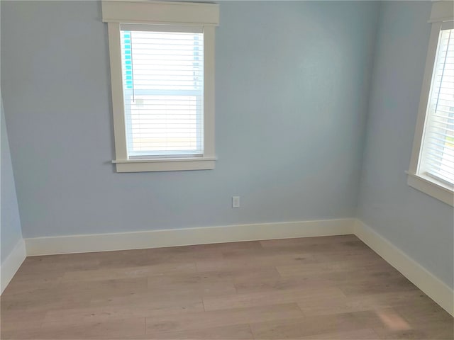 empty room with a healthy amount of sunlight and hardwood / wood-style flooring