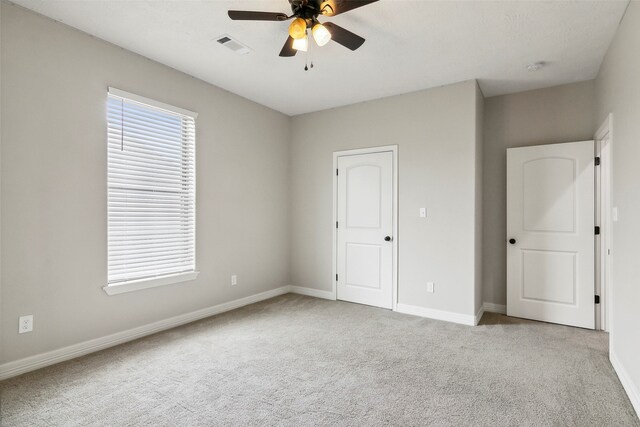 unfurnished bedroom with ceiling fan and light colored carpet