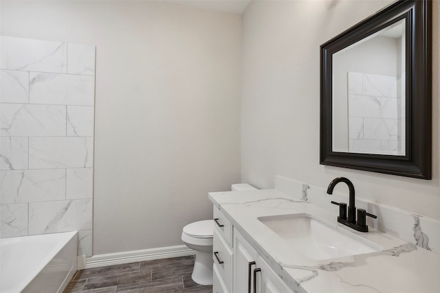 bathroom with vanity, toilet, a bath, and wood-type flooring