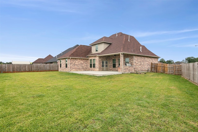 rear view of property with a lawn and a patio