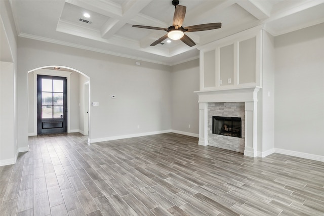 unfurnished living room featuring coffered ceiling, beam ceiling, light hardwood / wood-style floors, ornamental molding, and ceiling fan