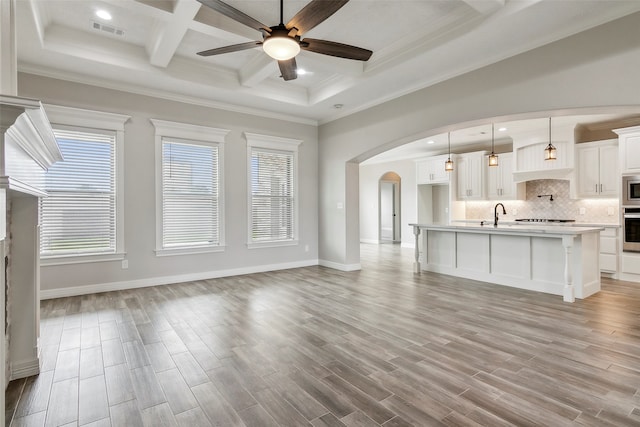 unfurnished living room with ceiling fan, a wealth of natural light, and light hardwood / wood-style floors