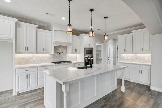 kitchen featuring appliances with stainless steel finishes, white cabinets, backsplash, and a breakfast bar