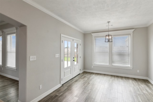 foyer with dark wood-type flooring, a textured ceiling, a notable chandelier, and french doors