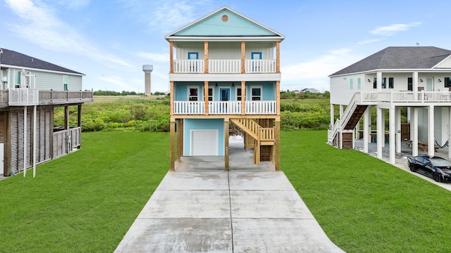 raised beach house featuring a garage, a front yard, a balcony, and covered porch