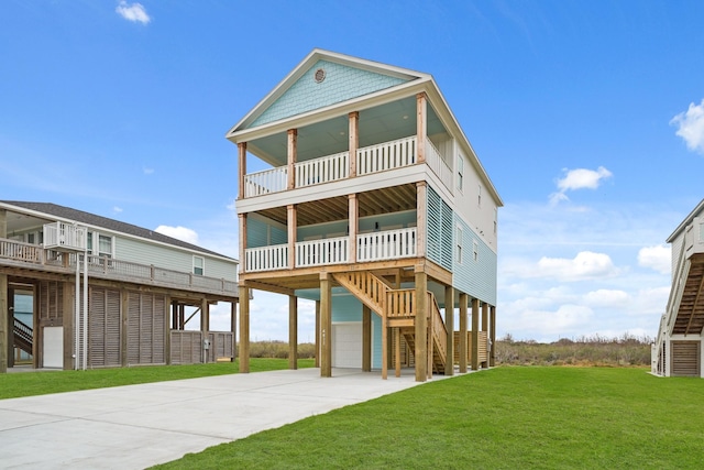 back of house featuring a garage, a balcony, a yard, and a carport