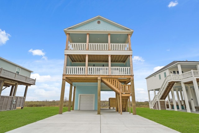 coastal home featuring a garage, a front lawn, a balcony, and covered porch