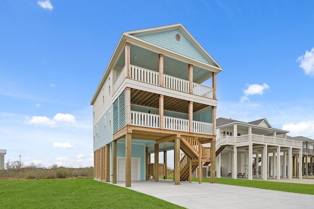 rear view of house featuring a garage, a balcony, a yard, and a carport