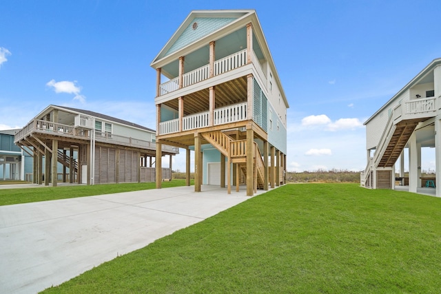 rear view of property featuring a balcony, a garage, and a lawn