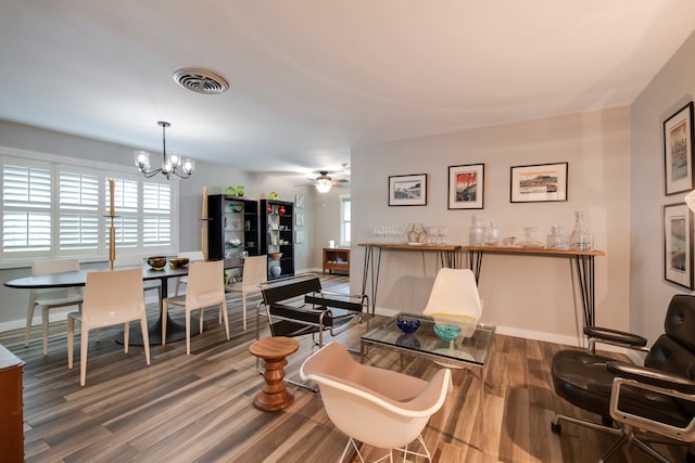 living room with dark wood-type flooring and ceiling fan with notable chandelier